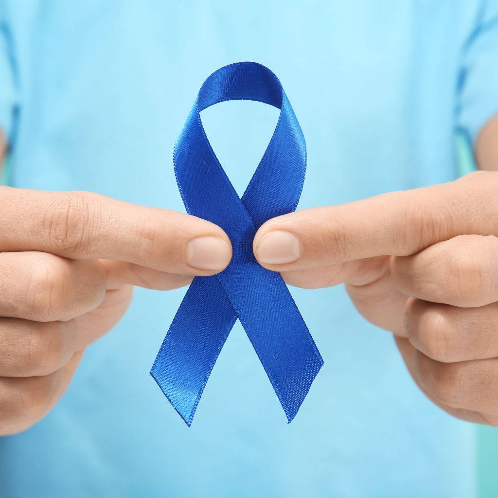 Mężczyzna trzymający niebieską wstążkę symbolizującą raka prostaty